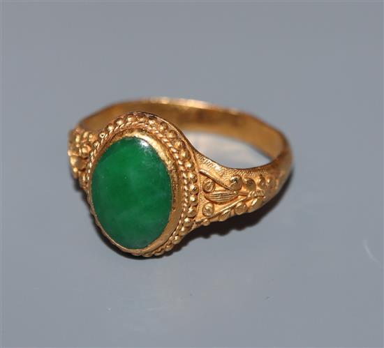 A Chinese yellow metal and cabochon jade set dress ring, size K/L.